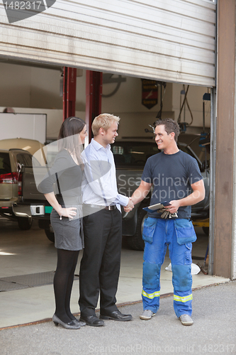 Image of Mechanic shaking hands with client