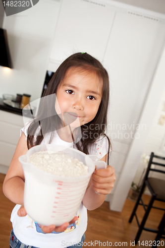 Image of Young Girl Baking Measuring Cup of Flour