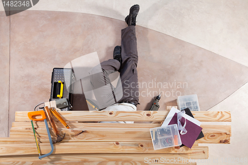 Image of Man working under wooden plank