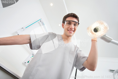 Image of Dentist adjusting lamp