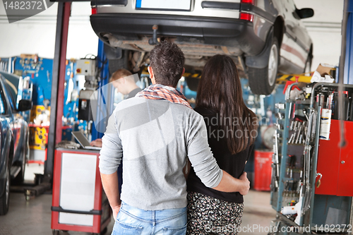 Image of Rear view of young couple in garage