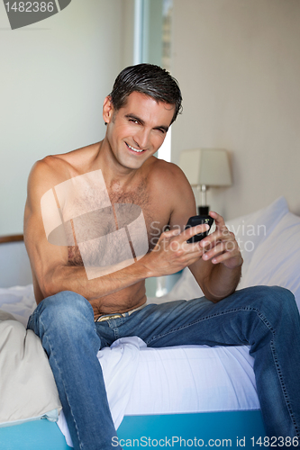 Image of Shirtless Man Using Cell Phone