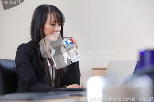 Image of Businesswoman drinking water at work