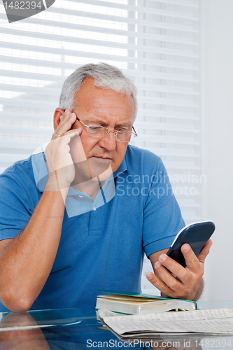 Image of Senior Man Holding Calculator