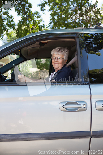 Image of Pretty senior woman driving car