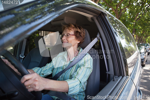 Image of Smiling senior woman driving car