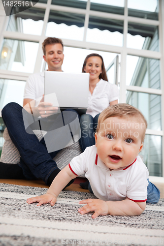 Image of Child on Floor - Parents Using Laptop