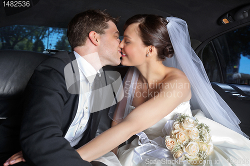 Image of Wedding Couple Kiss in Limo