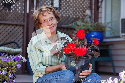 Image of Senior woman holding potted plant