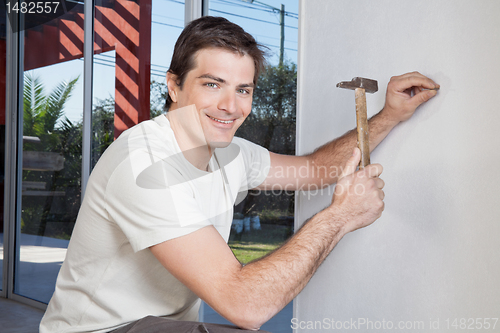 Image of Man hammering the wall