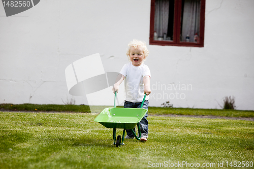 Image of Young Child Pushing Wheelbarrow