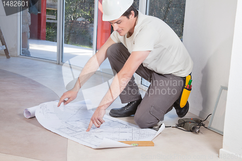 Image of Man pointing at blueprint