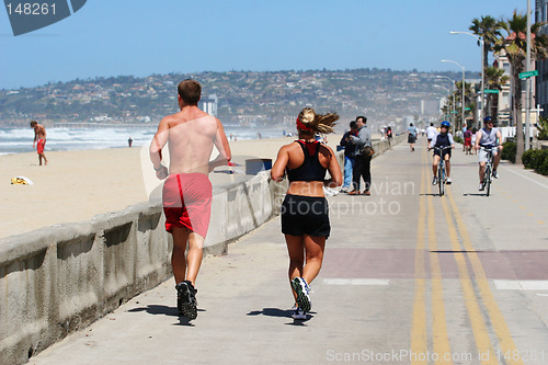 Image of Couple running along the beach