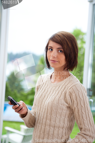 Image of Attractive female holding cell phone