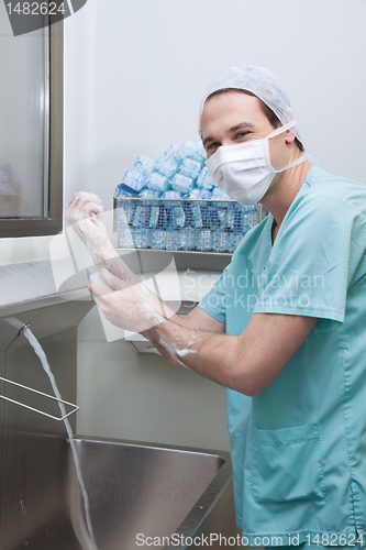 Image of Male doctor washing hands