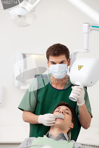 Image of Man Dentist Preparing X-ray