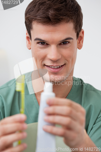 Image of Dentist holding toothpaste and toothbrush