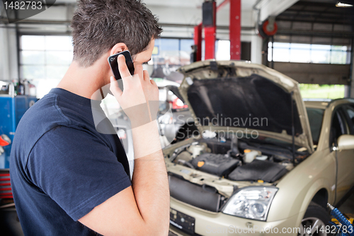 Image of Mechanic talking on cell phone