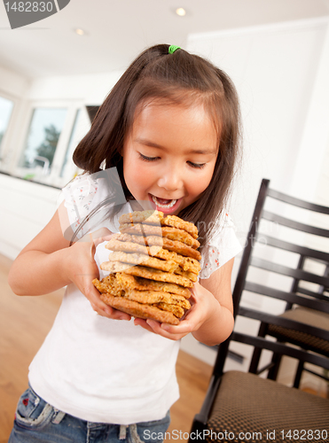 Image of Young Girl Eating Stack of Cookies