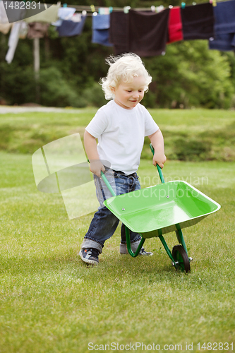 Image of Boy pushing a wheelbarrow