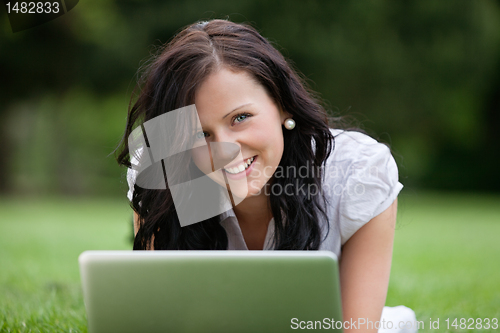 Image of Female Lying on Grass Using Laptop