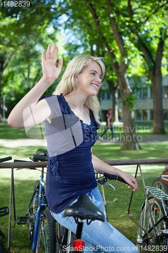 Image of College student waving hand at someone