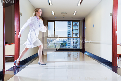 Image of Female doctor rushing in hallway