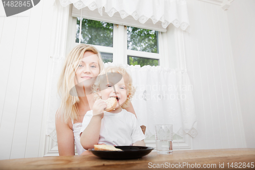 Image of Child Eating With Mother