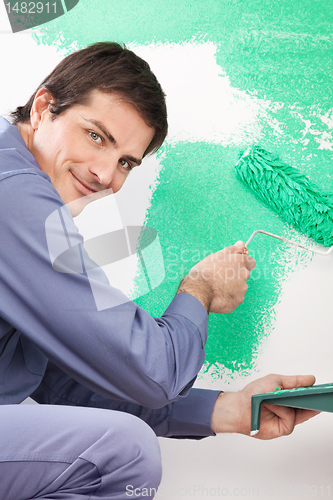 Image of Handsome man painting house