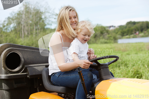 Image of Mother and Child mowing grass