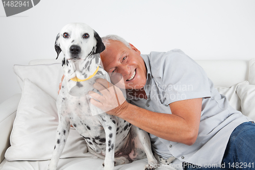 Image of Senior Man Sitting With His Pet Dog