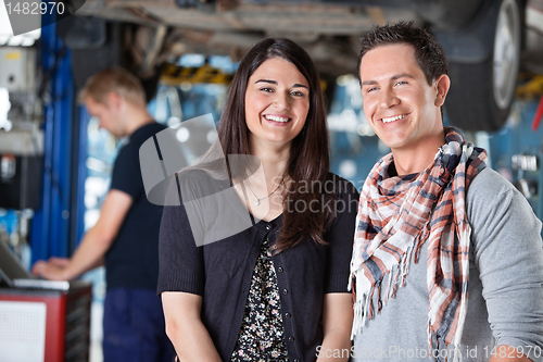 Image of Portrait of smiling young couple in mechanic shop