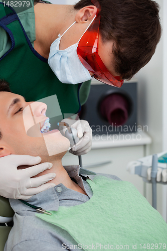 Image of Dentist working on tooth at dental clinic