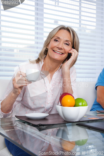 Image of Woman Using Cell Phone at Breakfast Table