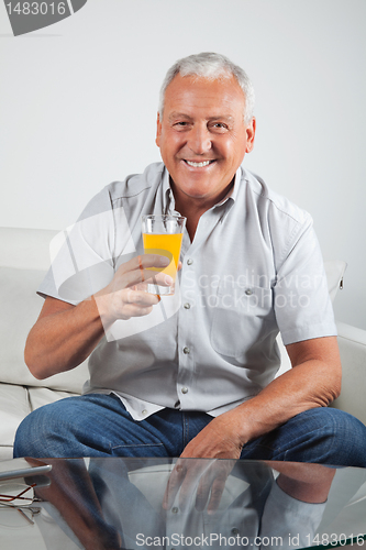 Image of Senior Man Having Fresh Orange Juice