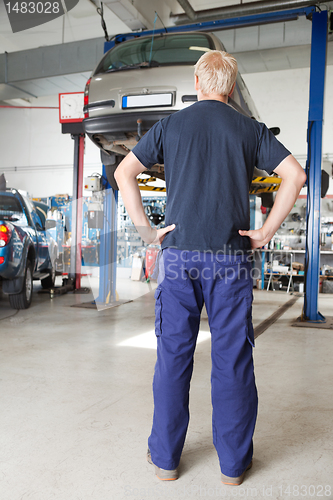 Image of Mechanic looking at car