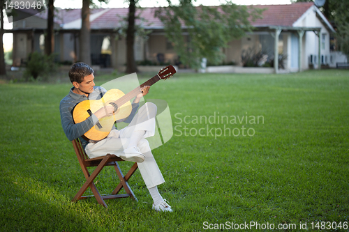 Image of Man Playing Guitar in Lawn