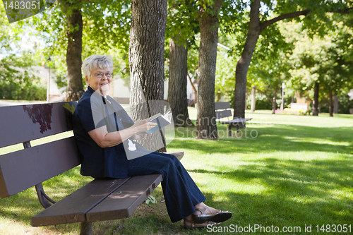 Image of Woman reading book in a park