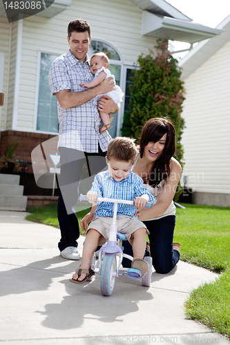 Image of Cheerful Mother Teaching Son To Ride Tricycle