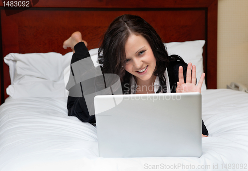 Image of Businesswoman Lying on Bed With Laptop