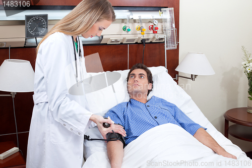 Image of Doctor checking blood pressure of patient