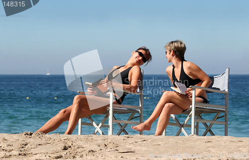 Image of 2 women reading on the beach