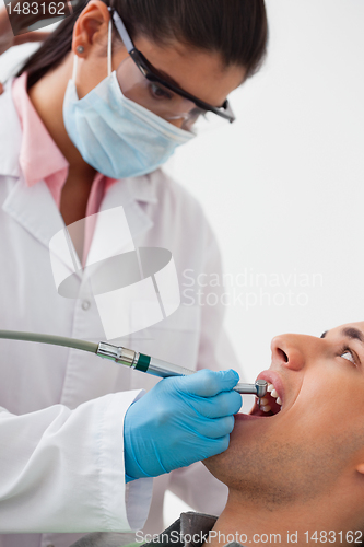 Image of Dentist Using Drill on Patients Teeth