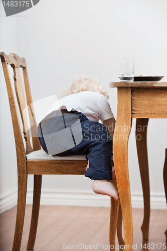Image of Child trying to get down from chair
