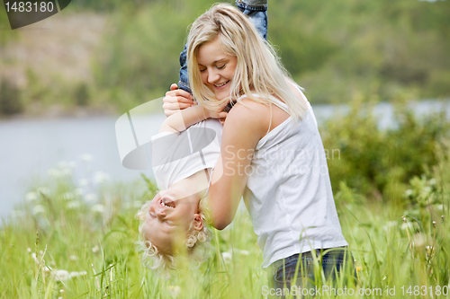 Image of Pretty woman playing with her son