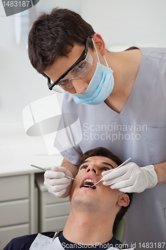 Image of Dentist examining patient's teeth