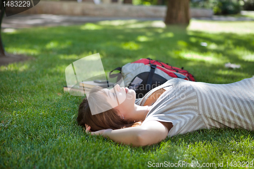 Image of Girl lying on grass at campus lawn