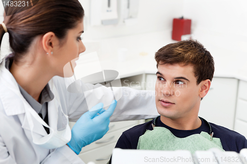 Image of Dentist having conversation with patient