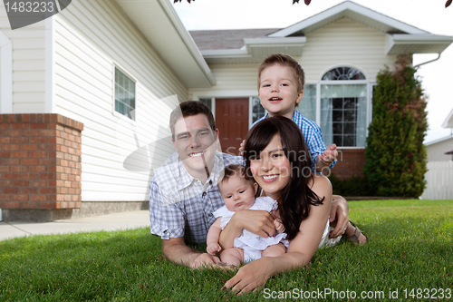 Image of Happy Family of Four Lying Down on Grass