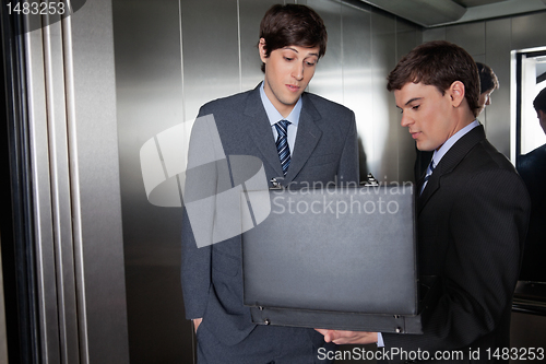 Image of Business Men with Briefcase in Elevator